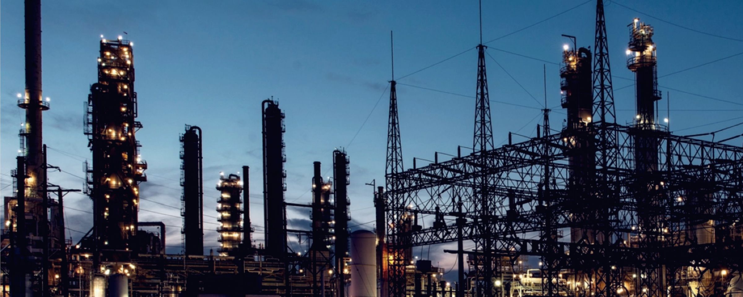 Refinery process towers and switchyard at dusk
